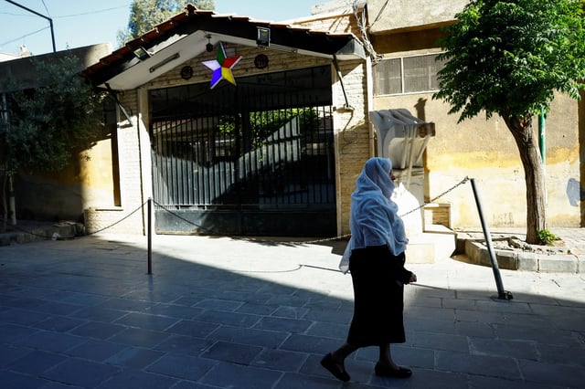 A Druze woman walks near a Druze mosque in Jaramana, Syria May 5, 2025. REUTERS/Yamam Al Shaar