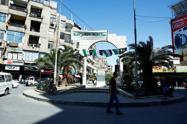 A man walks at Al-Karama Square in Jaramana, Syria May 5, 2025. REUTERS/Yamam Al Shaar