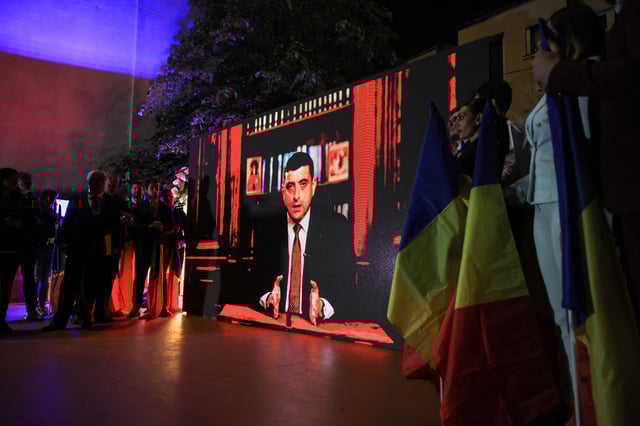 Supporters watch Leader of the radical right Alliance for the Union of Romanians (AUR) George Simion speak on a screen following the exit poll results during the Romanian presidential election, outside the Alliance for the Union of Romanians (AUR) headquarters in Bucharest, Romania, May 4, 2025. REUTERS/Louisa Gouliamaki/File Photo