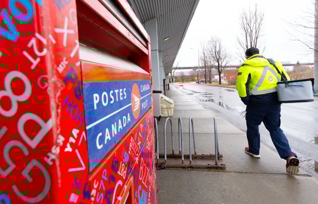 A Canada Post worker arrives for work in Montreal on Tuesday, Dec.17, 2024. THE CANADIAN PRESS/Christinne Muschi