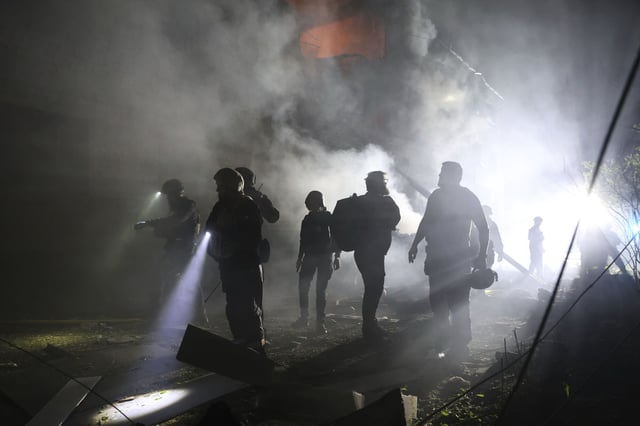 Personal de emergencias de Ucrania en el lugar donde ha impactado un misil en Zaporiyia.