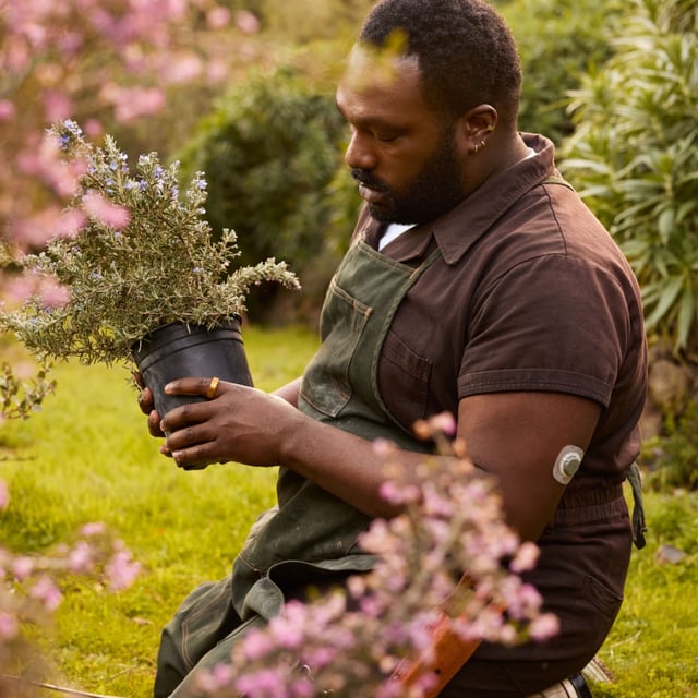 A person wearing an Oura Ring and Stelo Glucose Sensor while gardening