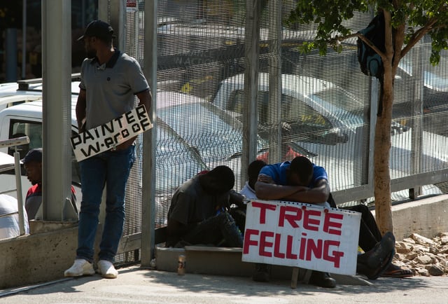 FILE - Workers advertise their skills looking for work outside a hardware store in a Johannesburg suburb, Wednesday, Feb. 26, 2020. (AP Photo/Denis Farrell, File)