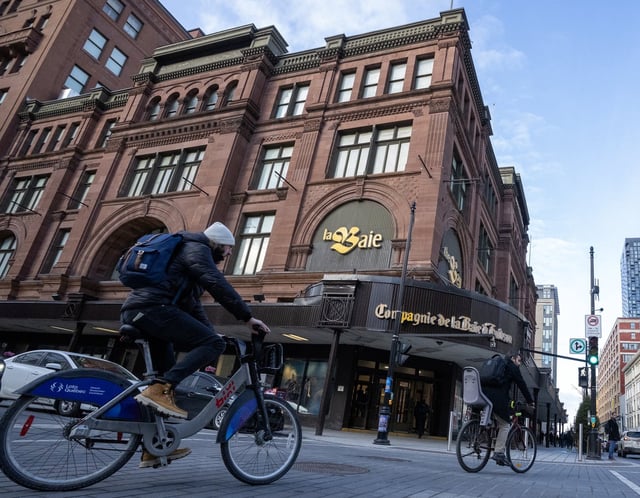 People cycle past the Hudson's Bay department store in downtown Montreal on Monday, March 17, 2025. THE CANADIAN PRESS/Christinne Muschi