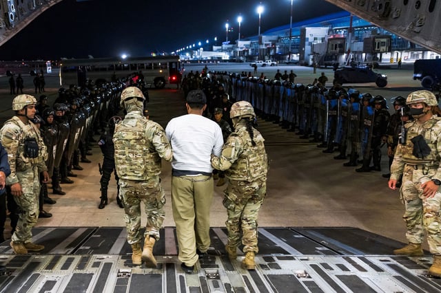 US military personnel escort an alleged gang member who was deported by the US along with others the US alleges are members of the Venezuelan gang Tren de Aragua and the MS-13 gang at the El Salvador International Airport in San Luis Talpa, El Salvador, April 12, 2025.