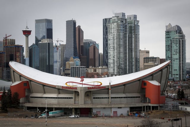 The city skyline is seen behind the Saddledome, home of the Calgary Flames, in Calgary, Alta., Thursday, March 12, 2020. THE CANADIAN PRESS/Jeff McIntosh