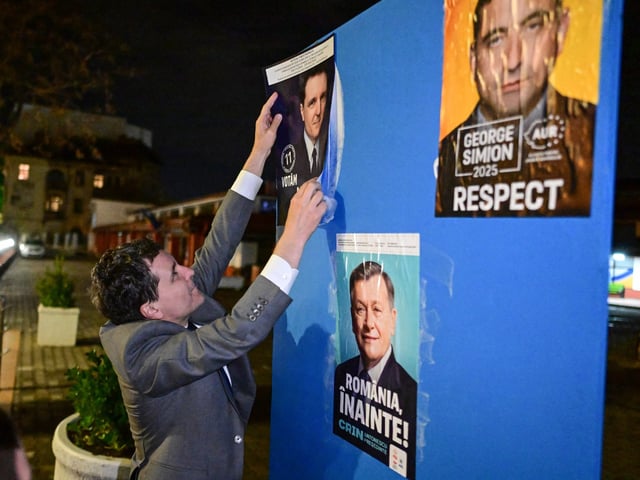 Mayor of Bucharest and presidential candidate Nicusor Dan pastes a campaign poster of himself on a specially designated board at the begining of the presidential election campaign in Bucharest on April 4, 2025. Romania's presidential election campaign officially begins Friday, with 11 candidates competing for the country's top office. The first round of voting scheduled for May 4. This year's election follows a controversial annulment of the 2024 presidential vote by the Constitutional Court. (Photo by Daniel MIHAILESCU / AFP) (Photo by DANIEL MIHAILESCU/AFP via Getty Images)