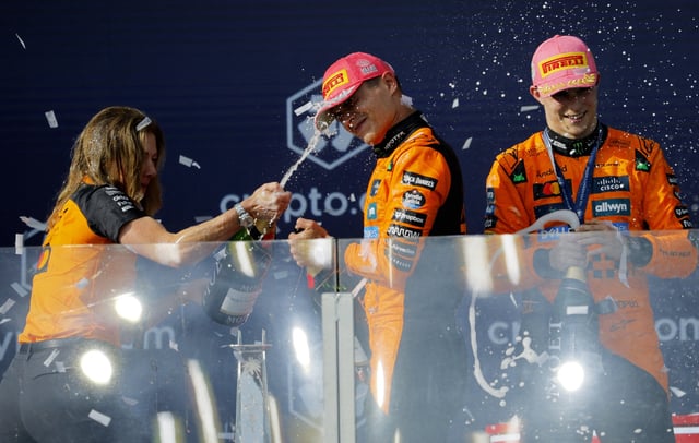 Formula One F1 - Miami Grand Prix - Miami International Autodrome, Miami, Florida, United States - May 4, 2025 McLaren's Oscar Piastri celebrates with champagne on the podium after winning the Miami Grand Prix alongside second placed McLaren's Lando Norris and McLaren Chief Marketing Officer Louise McEwen REUTERS/Brian Snyder