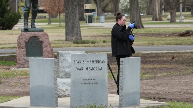 A crime scene investigator takes a photo and collects evidence after a cannon was stolen from the Spanish-American War monument in Central Riverside Park. The cannon was later recovered in pieces.