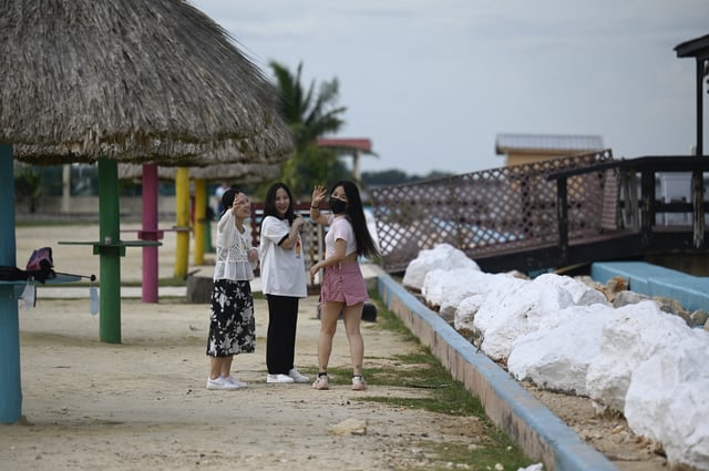 Tourists can be seen visiting the boardwalk in Belize City before the arrival of Tropical Storm Lisa on November 1, 2022. Photo by Johan ORDONEZ / AFP) (Photo by JOHAN ORDONEZ/AFP via Getty Images)
