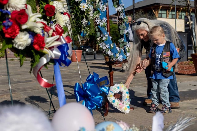 Cheryle “Lovey” Gollinger and her great-grandson Dusty Ray “Lil Buddy” Gollinger, 2, of San Antonio lay a wreath Friday outside the Bexar County Courthouse on April 1, 2022, to mark the beginning of National Child Abuse Prevention Month.