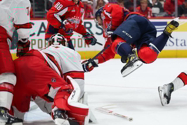 Alex Ovechkin #8 of the Washington Capitals goes airborne as he attempts to shoot the puck against the Carolina Hurricanes during the second period at Capital One Arena on April 10, 2025 in Washington, DC.