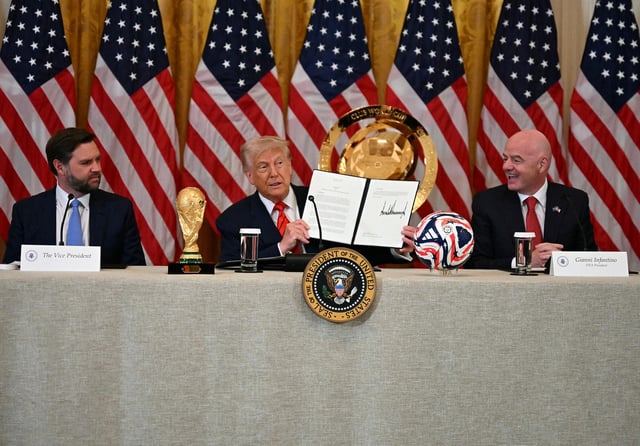 President Donald Trump holds up a document creating the "White House Task Force on the FIFA World Cup 2026" as US Vice President JD Vance, left, and FIFA president Gianni Infantino look on in the East Room of the White house in Washington, DC, on May 6.