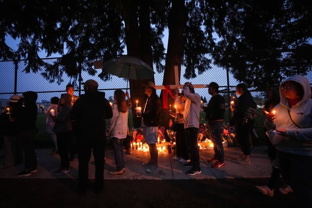 People gather for a candlelight march during a vigil on the street where a vehicle-ramming attack occurred at the Filipino community's Lapu Lapu Day festival last week, on a provincial day of mourning for the victims, in Vancouver, on Friday, May 2, 2025. THE CANADIAN PRESS/Darryl Dyck