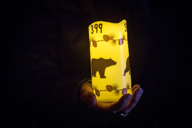 FILE - Catherina Gallegos holds a decorated candle in memory of grizzly bear No. 399 at a candlelight vigil in Jackson, Wyo. on Nov. 2, 2024. (AP Photo/Amber Baesler, File)