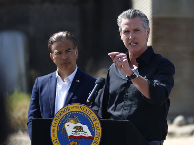 Gavin Newsom speaks as California Attorney general Rob Bonta looks on during a news conference at Gemperle Orchard on April 16, 2025 in Ceres, California.