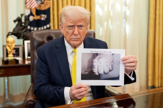 President Donald Trump poses with a digitally altered image of Kilmar Abrego Garcia’s knuckles, where the letters “MS-13” have been added above Garcia’s existing tattoos, in a Truth Social post made on April 21.