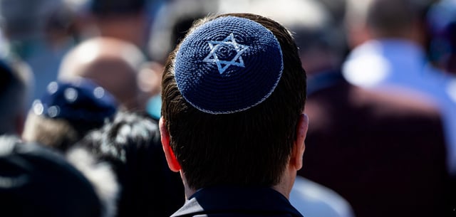Ein Besucher trägt eine Kippa mit einem Davidstern während einer Gedenkveranstaltung auf dem Gelände der Gedenkstätte Bergen-Belsen