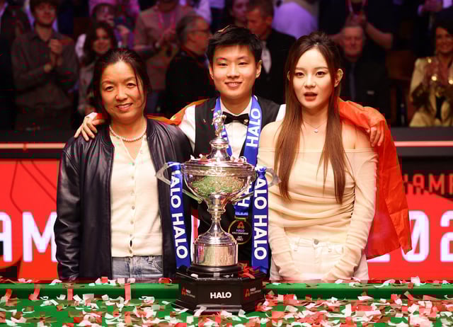 Snooker - World Snooker Championship - The Crucible Theatre, Sheffield, Britain - May 5, 2025 China's Xintong Zhao poses with the trophy, his manager Victoria Shi and his partner Yi yi after winning his final match against Wales' Mark Williams Action Images via Reuters/Andrew Boyers