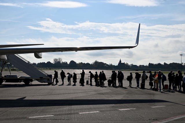 People waiting to get on a plane on the runway. Credit: SJBright / Alamy Stock Photo.
