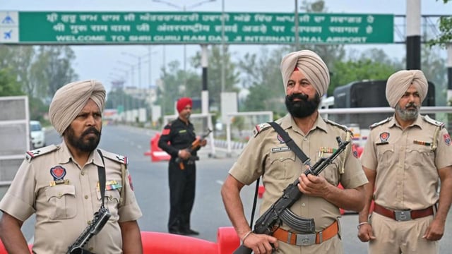 Policemen stand guard on the entrance road of the Sri Guru Ram Dass Jee International Airport on the outskirts of Amritsar on May 7. (AFP)