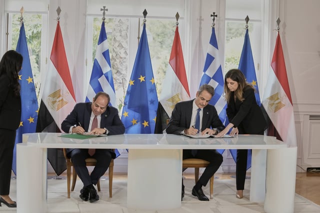 Greece's Prime Minister Kyriakos Mitsotakis, right, and the Egyptian President Abdel-Fattah el-Sissi sign bilateral agreements during their meeting in Athens, on Wednesday, May 7, 2025. (AP Photo/Petros Giannakouris)