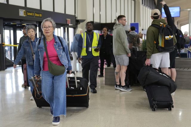People prepare to board flights at Newark Liberty International Airport in Newark, N.J., Monday, May 5, 2025. (AP Photo/Seth Wenig)