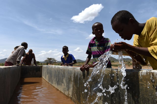 Children drink water from a pipeline in the village of Afraaga, Somaliland. Credit: Joe Giddens / Alamy Stock Photo