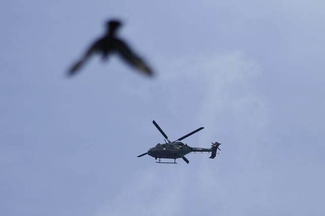 Indian army's helicopter and a bird fly over the sky in Srinagar, Indian controlled Kashmir, Monday, May. 5, 2025. (AP Photo/Mukhtar Khan)