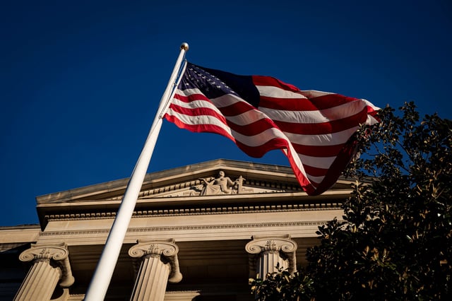 An American flag waves outside the U.S. Department of Justice Building in Washington, U.S., December 15, 2020. REUTERS/Al Drago/ File Photo