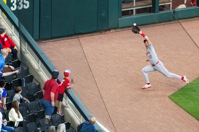 ATLANTA, GA - MAY 05: Tyler Callihan #32 of the Cincinnati Reds makes a catch during the game against the Cincinnati Reds at Truist Park on May 5, 2025 in Atlanta, Georgia. Callihan broke his forearm after making the catch and slamming into the wall.