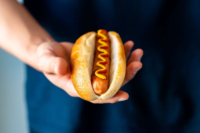 Hot dog with fresh organic bread bun white wheat and black charcoal sausage ketchup mustard