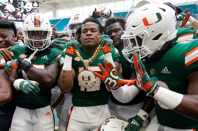 Miami safety Avantae Williams, center, wears a &#34;turnover chain,&#34; as he celebrates with teammates after he intercepted a pass during the first half of an NCAA college football game against Georgia Tech, Saturday, Nov. 6, 2021, in Miami Gardens, Fla. (AP Photo/Wilfredo Lee)