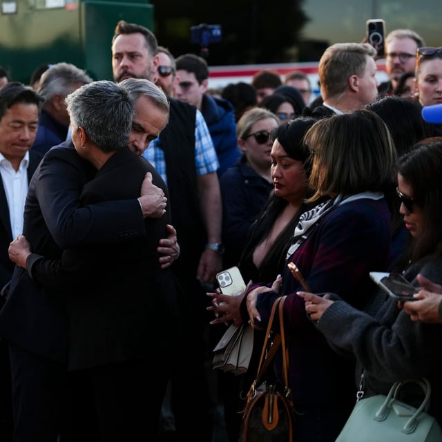 Liberal Leader Mark Carney hugs Mable Elmore, MLA for Vancouver Kensington, as they visit a memorial for the Lapu Lapu Day block party tragedy in Vancouver, B.C., on Sunday, April 27, 2025. THE CANADIAN PRESS/Sean Kilpatrick