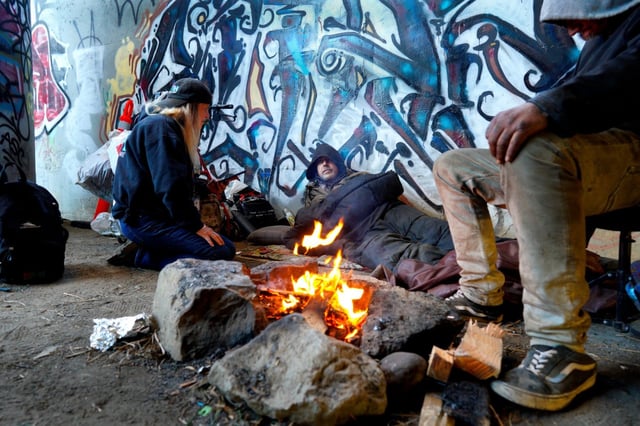 Terri Sickels interviewed David (m) and James (r) during the annual point-in-time count for those living unsheltered. David has been homeless for the past 5 years and James for more than a year now. Both men are currently living at an encampment under the 163 freeway in Mission Valley near the San Diego Riverbed on Thursday, Jan. 30, 2025, in San Diego, CA. (Nelvin C. Cepeda / The San Diego Union-Tribune)