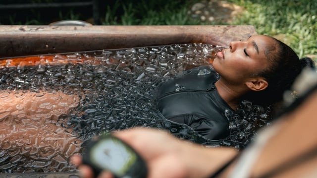 Women practicing necessary steps for ice bath therapy, pinching their noses with their fingers to hold their breath, listening carefully to the instructor, mentally preparing for a new and revitalizing healing experience