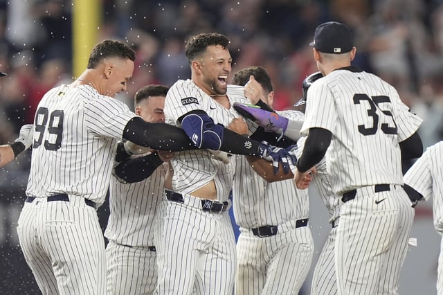 New York Yankees' J.C. Escarra, center, celebrates with teammates after hitting a walk-off sacrifice fly ball during the 10th inning of a baseball game against the San Diego Padres Wednesday, May 7, 2025, in New York. (AP Photo/Frank Franklin II)