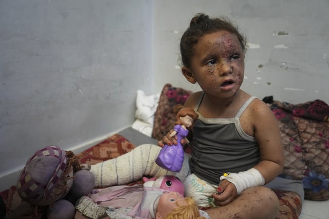 Layan Ibrahim Sahloul, 4, sits despondently among her dolls at Nasser hospital with second-degree burns on her face, foot, and stomach, caused a week earlier during an Israeli army strike on her home in Khan Younis that killed her pregnant mother and two siblings and buried her under the rubble, in Khan Younis, Gaza Strip, Sunday, May 4, 2025.(AP Photo/Abdel Kareem Hana)