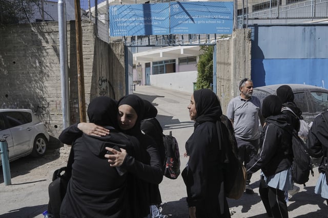 Students stand outside of UNRWA Girls School run by the U.N. agency for Palestinian refugees in the Shuafat Refugee Camp in east Jerusalem, Thursday, May 8, 2025. After Israeli forces ordered the closure of six of its schools in east Jerusalem Thursday. (AP Photo/Mahmoud Illean)