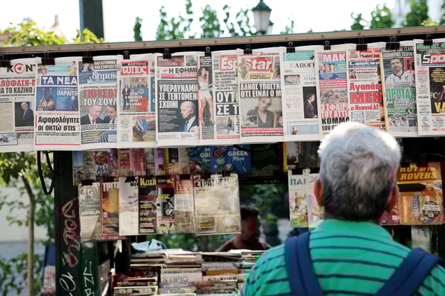 A man looks at newspaper headlines at a kiosk, a day after U.S. President Joe Biden announced that he is dropping his reelection bid, in Athens, Greece, July 22, 2024. REUTERS/Louiza Vradi/File Photo
