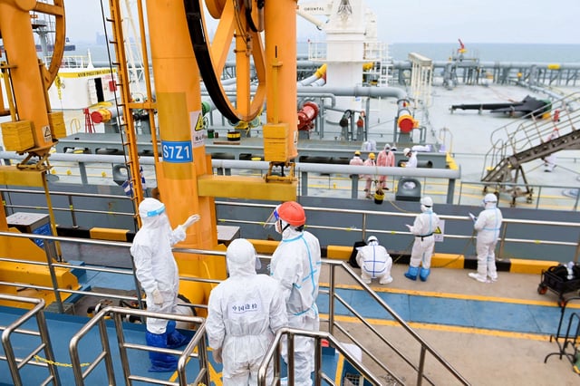 Immigration inspection officers in protective suits check a tanker carrying imported crude oil at the port in Qingdao, Shandong province, China May 9, 2022. Picture taken May 9, 2022. China Daily via REUTERS  ATTENTION EDITORS - THIS IMAGE WAS PROVIDED BY A THIRD PARTY. CHINA OUT./File Photo