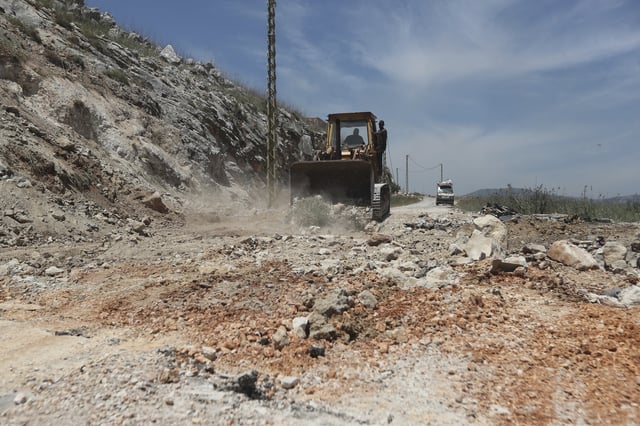 A bulldozer closes a crater following Israeli airstrikes that targeted hilltops near Nabatieh town, south Lebanon, Thursday, May 8, 2025. (AP Photo/Mohammed Zaatari)