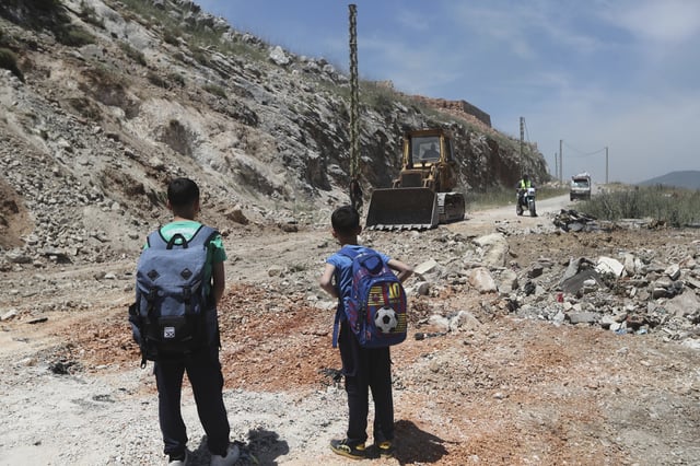 A bulldozer fills a crater following Israeli airstrikes that targeted hilltops near Nabatieh town, south Lebanon, Thursday, May 8, 2025. (AP Photo/Mohammed Zaatari)