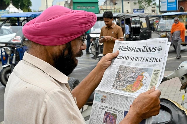 Un hombre lee un periódico con un artículo en portada sobre el conflicto entre India y Pakistán en Amritsar, el 8 de mayo de 2025, un día después de que India lanzara ataques contra Pakistán