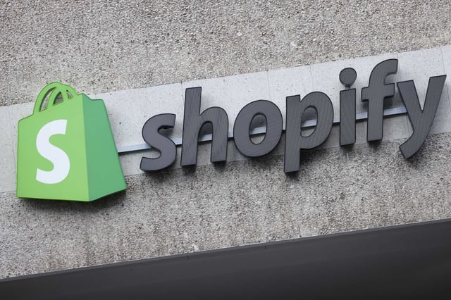 BERLIN, GERMANY - AUGUST 08: The corporate logo of e-commerce company Shopify hangs at the building that contains the offices of Shopify Commerce Germany GmbH on August 08, 2022 in Berlin, Germany. Shopify is a leading, Canada-based company that enables online and brick-and-mortar commerce. (Photo by Sean Gallup/Getty Images)