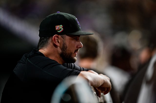 DENVER, COLORADO - AUGUST 16: Kris Bryant #23 of the Colorado Rockies looks on in the dugout wearing a customized hat for MLBs Players Weekend during a game between the Colorado Rockies and the San Diego Padres at Coors Field on August 16, 2024 in Denver, Colorado. (Photo by Dustin Bradford/Getty Images)