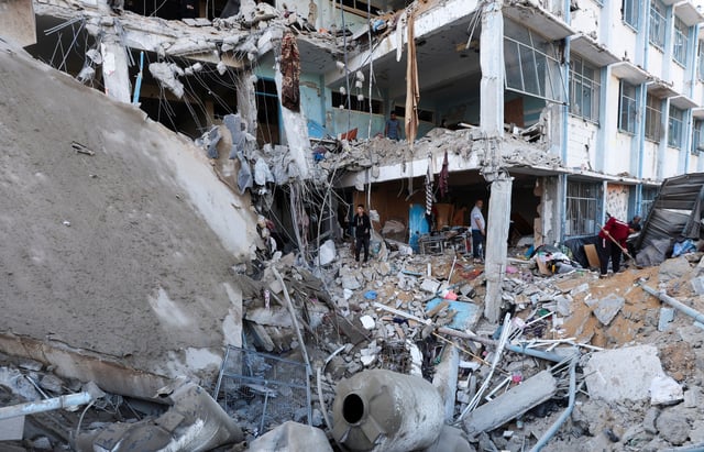 Palestinians inspect the site of an Israeli strike on an UNRWA school sheltering displaced people, in the Bureij camp in the central Gaza Strip, May 7, 2025. REUTERS/Ramadan Abed