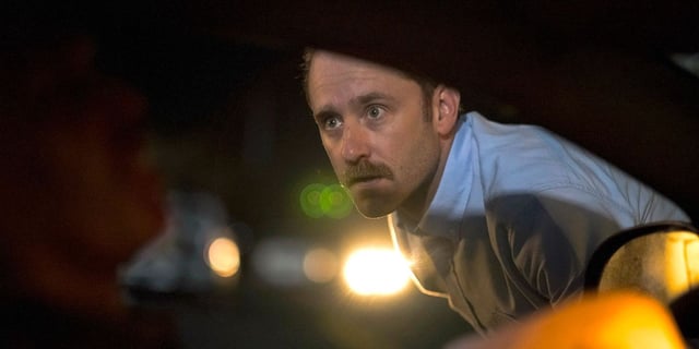 Ben Foster as Josh peering into a crashed car in Sharp Corner.