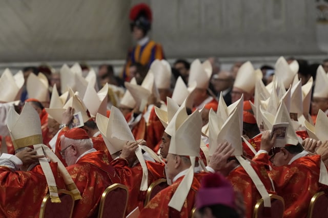 Cardinals adjust their mitre hats during a final Mass celebrated by cardinals inside St. Peter&#39;s Basilica before the conclave to elect a new pope, at the Vatican, Wednesday, May 7, 2025.