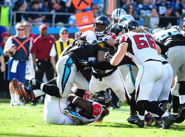 CHARLOTTE, NC - DECEMBER 13: Jonathan Stewart #28 of the Carolina Panthers is tackled by Joey Mbu #74, Brooks Reed #56, and Grady Jarrett #97 of the Atlanta Falcons at Bank Of America Stadium on December 13, 2015 in Charlotte, North Carolina.